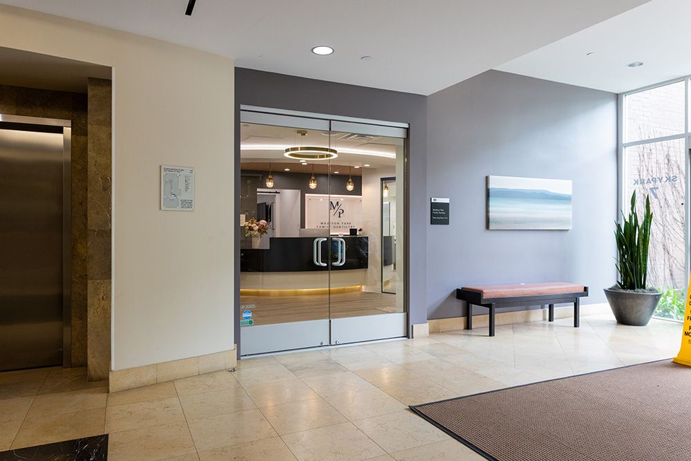 Entrance to Madison Park Family Dentistry with glass doors and modern interior visible from hallway
